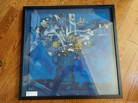 Full view of framed artwork on hardwood floor