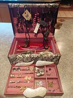 Jewelry box open showing hanging necklaces, tray, barrettes, assorted jewelry