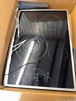 Glass touch control panel with burner-style markings visible