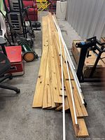 Stack of pine boards and white PVC strips on floor