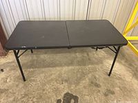 Black folding utility table unfolded