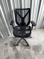 Front view of black mesh office chair showing seat, backrest and armrests