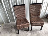 Two high-back rattan chairs front view showing overall design and wear