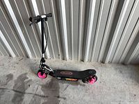 Full side view of scooter showing deck, wheels and handlebars