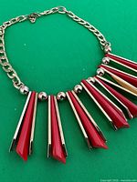 Close view of bib detailing and chain link on green background