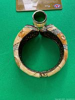 Bangle closed with ring sitting on top for scale