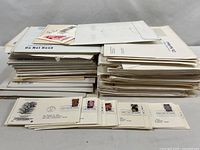 Overall view of two stacks of PCS mailers and loose First Day Covers