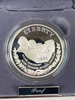 Obverse of proof coin in capsule inside presentation case