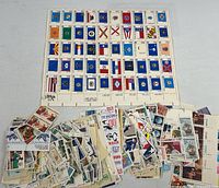 Full sheet of state flag stamps with piles of loose stamps