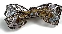 front view of filigree bow brooch showing design and two-tone finish