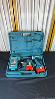 Complete drill set in case showing drill, charger, two batteries, carry case
