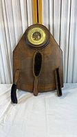 Full view of wooden plaque with barometer and three brushes