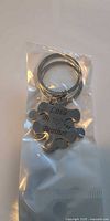 Close-up of single keychain in packaging showing puzzle shape, engraving and ring