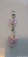 Close-up of one keychain showing clasp, bow, beads and heart charm