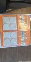 Sealed retail pack of eight white round skid protector pads in open box