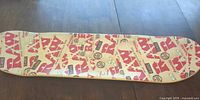 Top view of skateboard deck showing RAW logo pattern