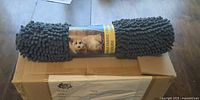 Rolled mat on shipping box showing label with dog image