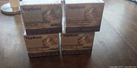 Front view of four shrink-wrapped TopSum pheromone refill boxes stacked on table