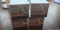Four sealed TopSum pheromone refill boxes stacked