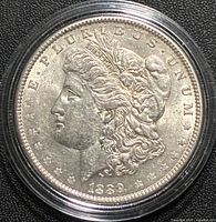 Obverse of 1889 Morgan silver dollar in protective capsule
