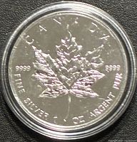 Reverse side of coin showing maple leaf and silver fineness