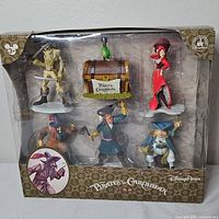 Front view of sealed Disney Parks Pirates of the Caribbean figurine set showing all contents