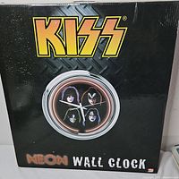 Front of sealed retail box showing Kiss logo and clock image