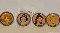 Front view of four drawer pulls showing Aurora, Snow White, Belle, Cinderella designs
