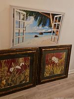 All three framed artworks leaning against wall