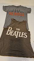 Both Beatles shirts laid flat showing front graphics
