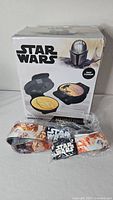 Front of boxed Mandalorian waffle maker and wrapped belt