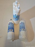 Three Tier1 refrigerator water filters, two unwrapped, one bubble-wrapped