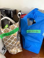 Two bags labeled light bulbs showing patterned and blue bags on table