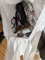 View inside bag showing eyeglasses, cases, lens cleaner