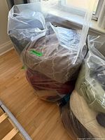Two clear bags labelled bedding filled with various comforters, blankets, sheets