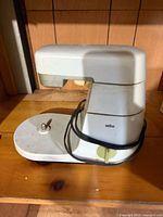 Braun white stand mixer base showing spindle, speed dial, and wrapped cord