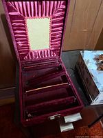 Jewelry box open showing interior velvet lining, mirror and three bangle rods