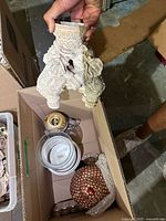 White triple-elephant pedestal stand partially visible in box