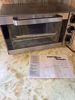 Front view of Hamilton Beach toaster oven with manual