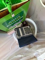 Overhead view showing Swiffer Sweeper kit box, curtain panel package, plastic basin with items