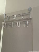 Silver over-the-door hook rack mounted on door