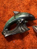 Green glazed ceramic dolphin sculpture on wave base