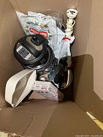 Boxed lot showing pressure cooker lid, hand blender, baking dish, accessory box and cookware items