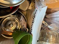 Top view of box showing stainless pots, lids, Nutribullet Pro box, green cup