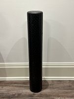 Full view of black 36-inch foam roller standing upright