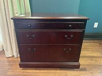 Front view showing two large drawers, top narrow drawer, brass-tone hardware