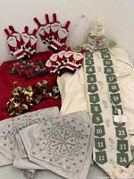 Group shot of all items including tablecloth, advent calendar, Santa holders, coasters, bells, grey napkins, LED light