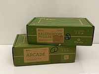 Two boxed KiwiCo kits stacked showing front labels Arcade and Kaleidoscope Puzzles