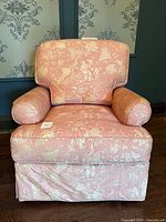 Full front view of pink toile armchair showing skirt and cushions