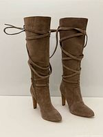 Full view of both knee-high suede boots standing upright